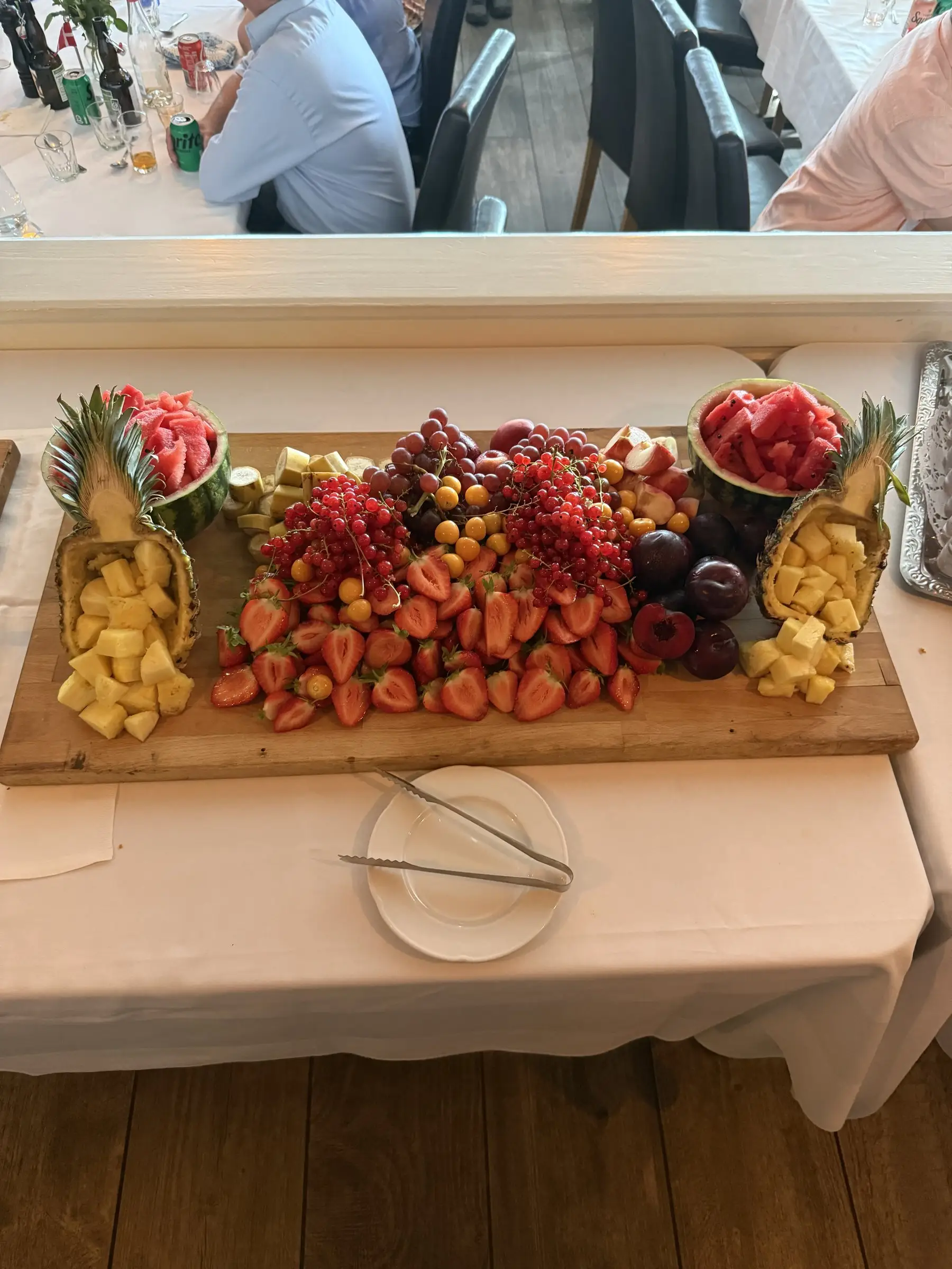 Bræt med frisk frugt, jordbær, ananas og vindruer til buffeten