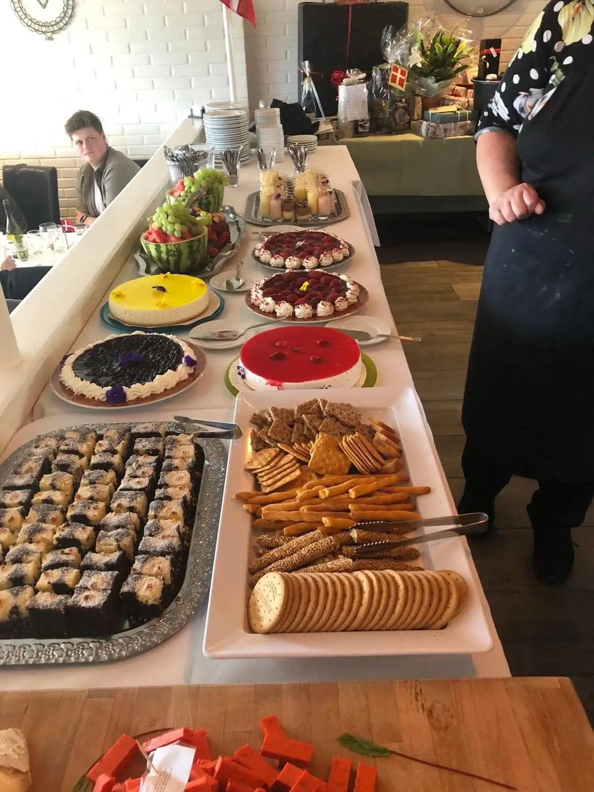 Kagebord med lagkager, småkager og frugt til et selskab