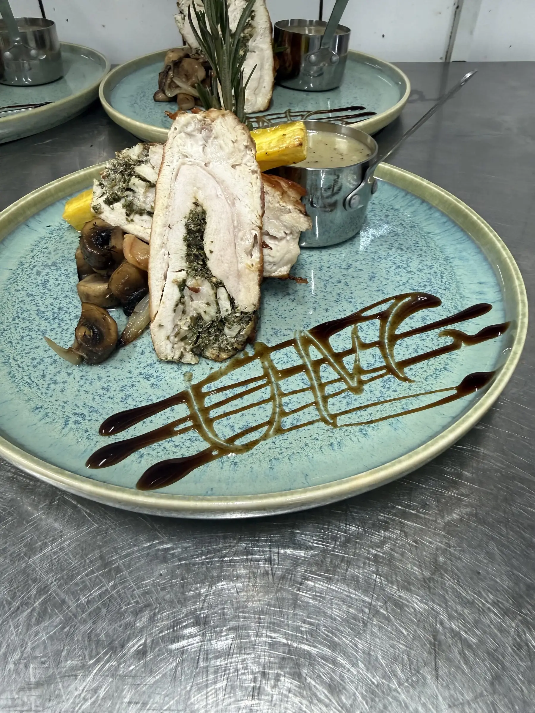 Kyllingeroulade med svampe, sauce og dekoration på tallerkenen