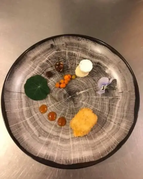 Dessert med havtorn, creme og en stedmoderblomst