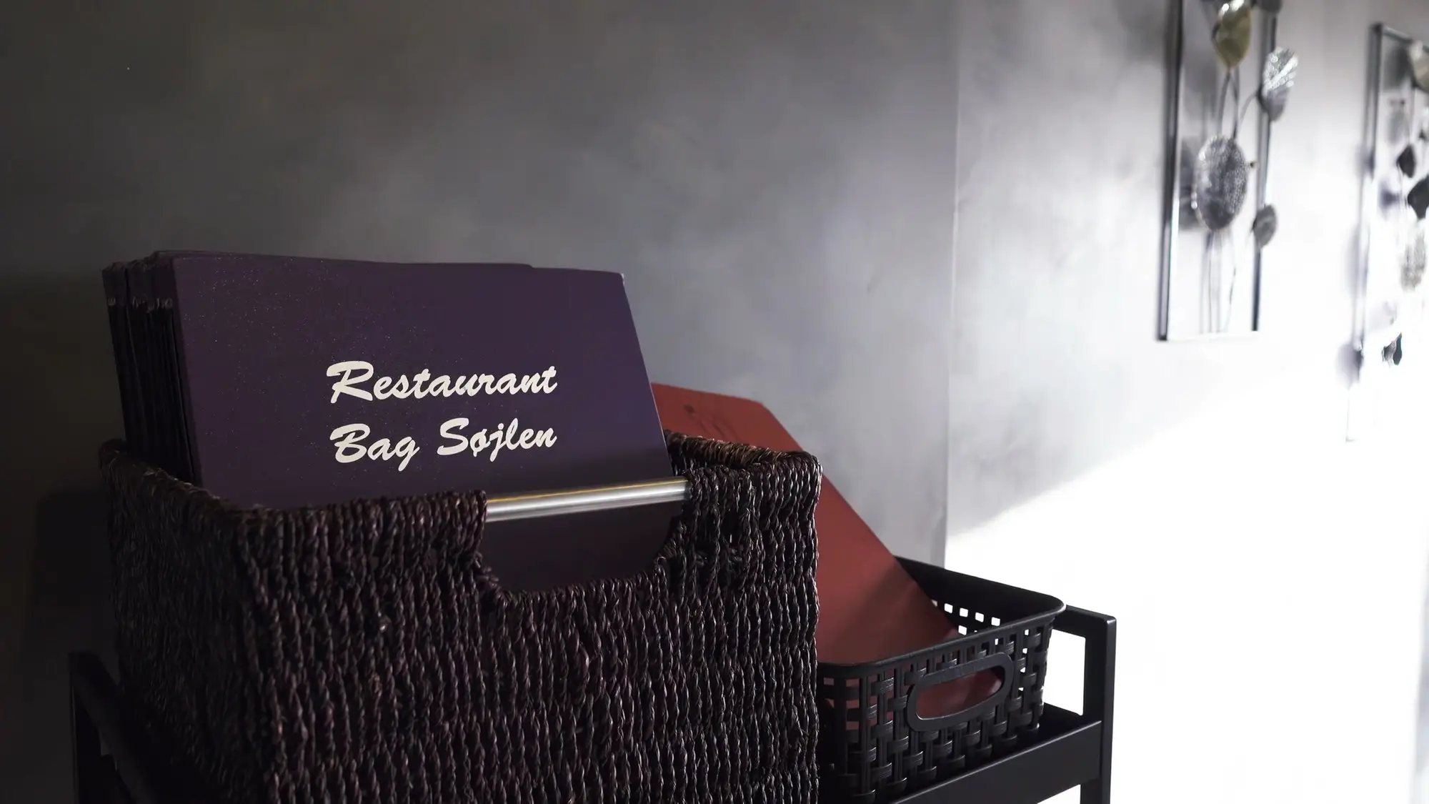 Restaurantens egne menumapper med guldtryk står klar i køkkenet