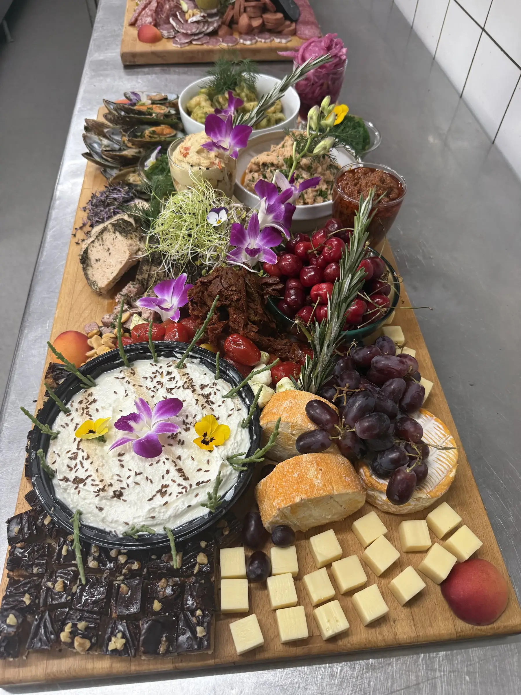 Tapasbræt med oste, kirsebær, chokolade og spiselige blomster